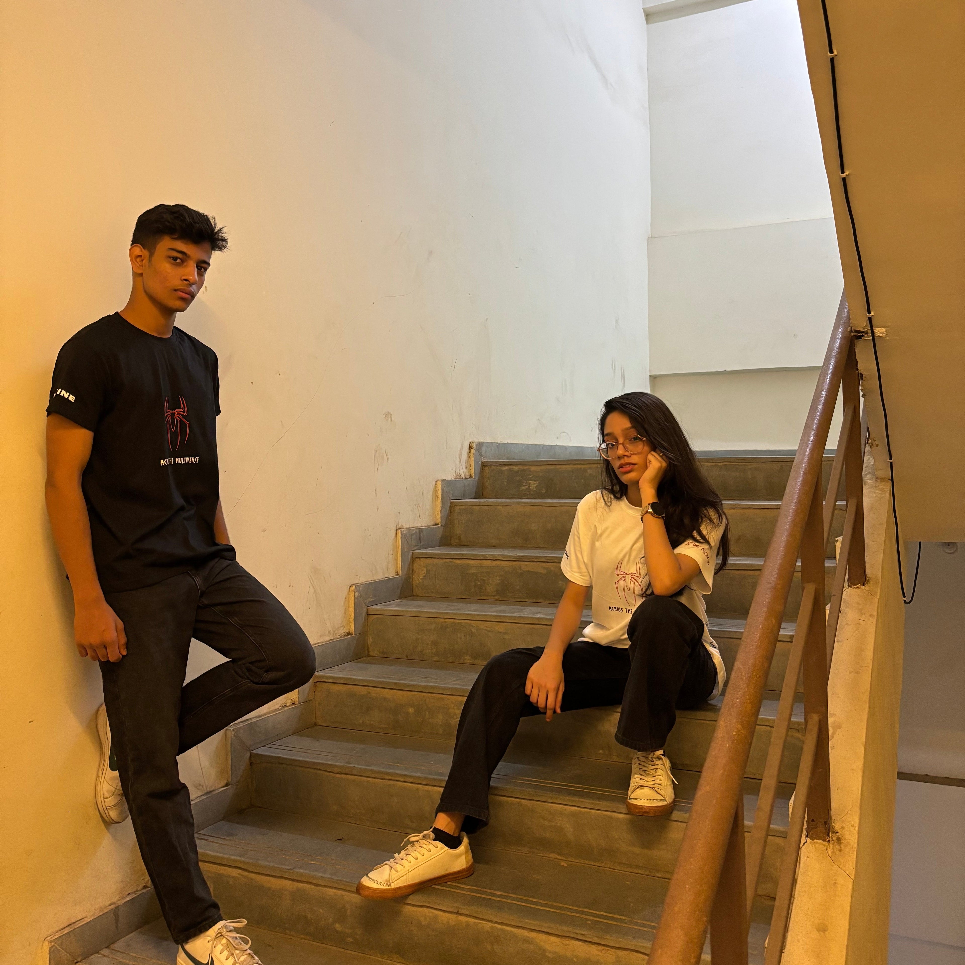 Two people sitting on a staircase in a modern building.