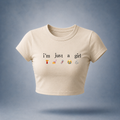 Off-white / Beige crop top with text 'I'm just a girl' and emojis on a bluish white background