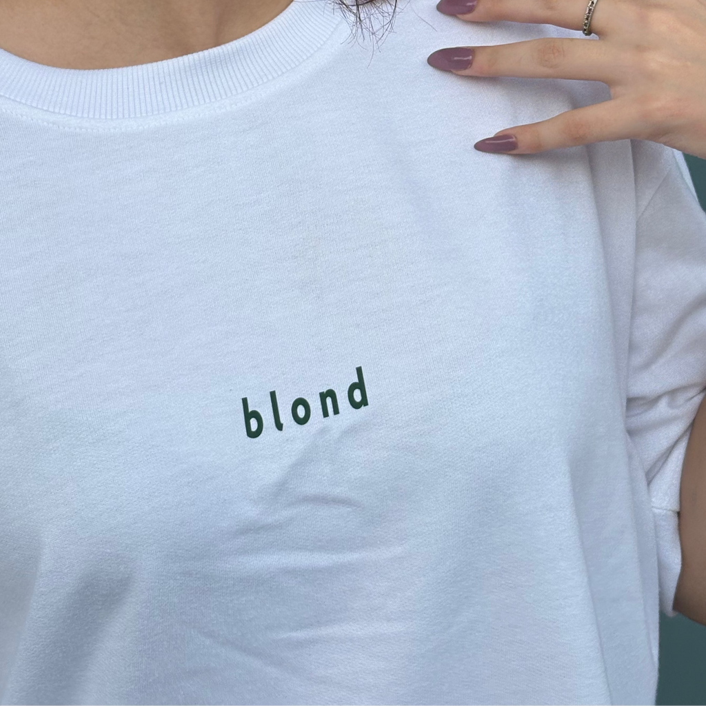 White sweatshirt with 'blond' text on a person wearing it.
