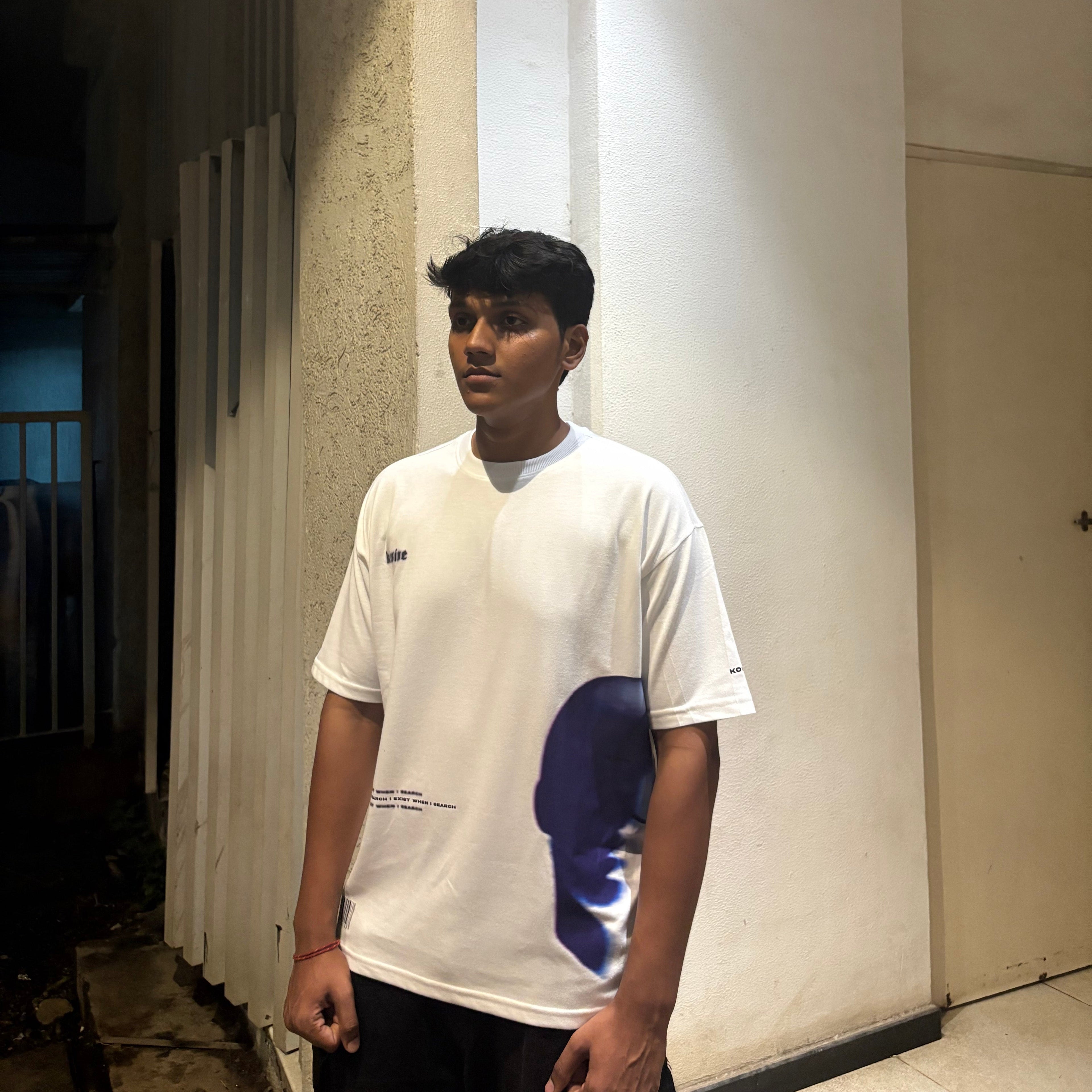 Person wearing a white t-shirt with a logo in an indoor setting