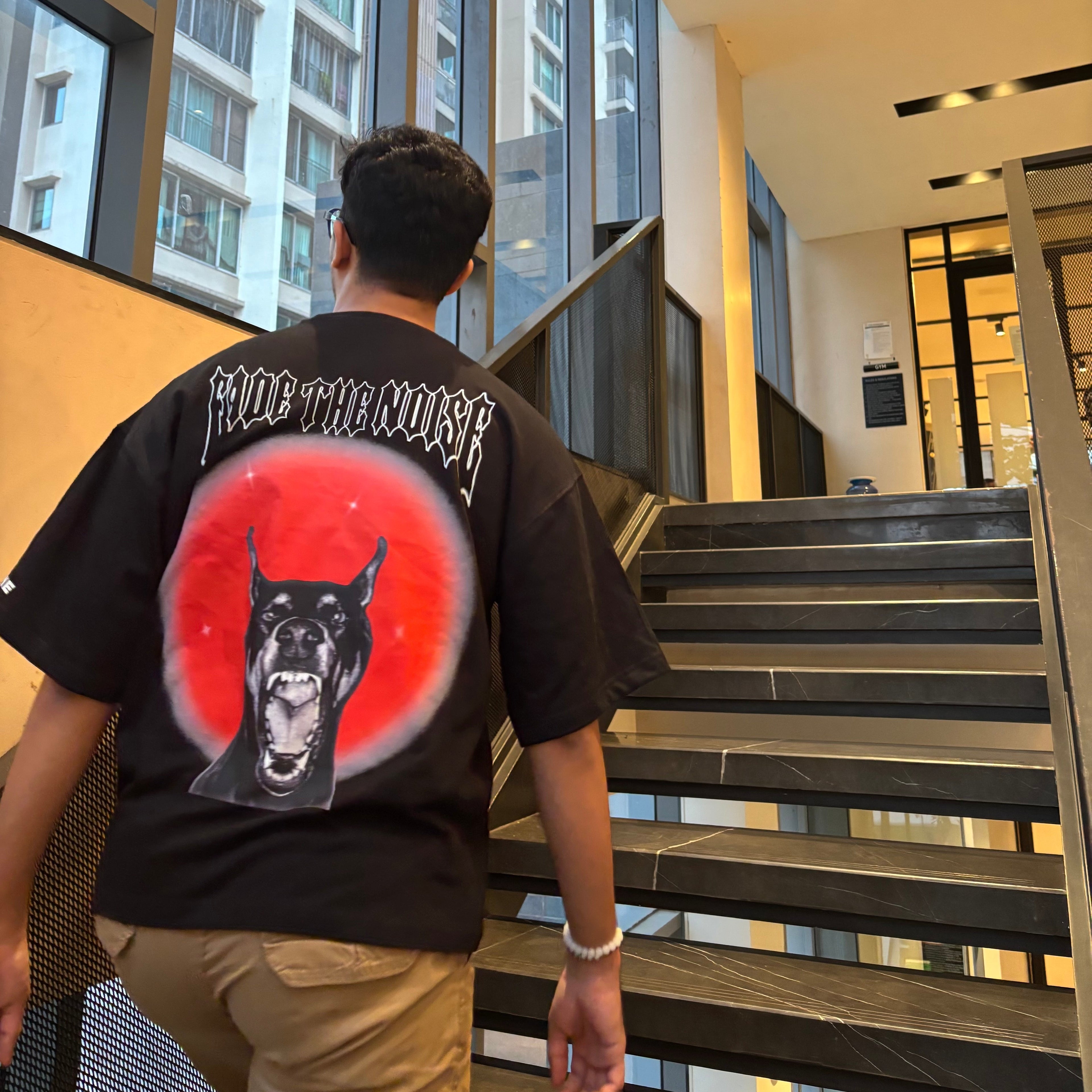 Person wearing a black t-shirt with a graphic design in an indoor setting